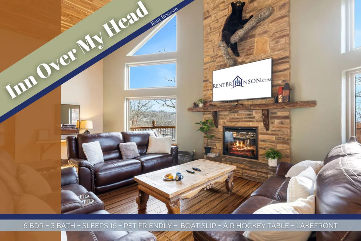 A beautifully arranged living room featuring a large stone fireplace, generous comfortable seating, large windows allowing sunlight to flood the space, a wooden coffee table, and a television. The open layout encourages gatherings and relaxation, with an inviting, warm ambiance perfect for family or friends.